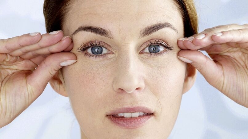 A woman holds her hands near her eyes