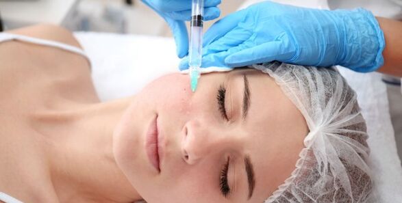 A beautician performs a facial skin rejuvenation procedure with plasma